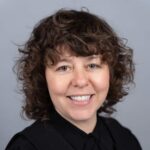 Elizabeth Wimbush - smiling woman with curly brown hair