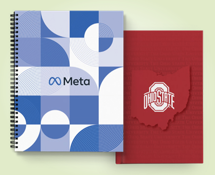 custom spiral notebook with blue-and-white cover and Meta logo, overlaying red custom notebook with Ohio State logo